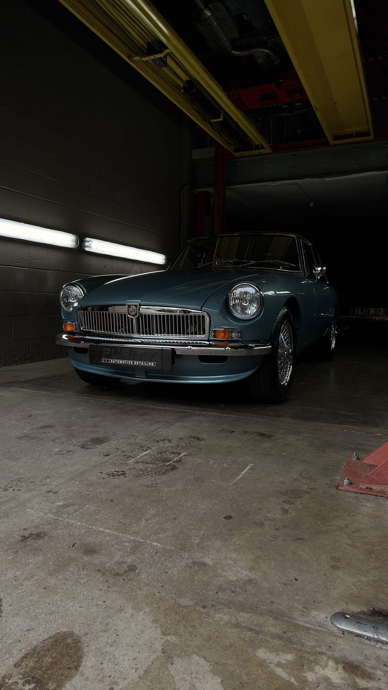 Light blue MGB GT in the detailing studio